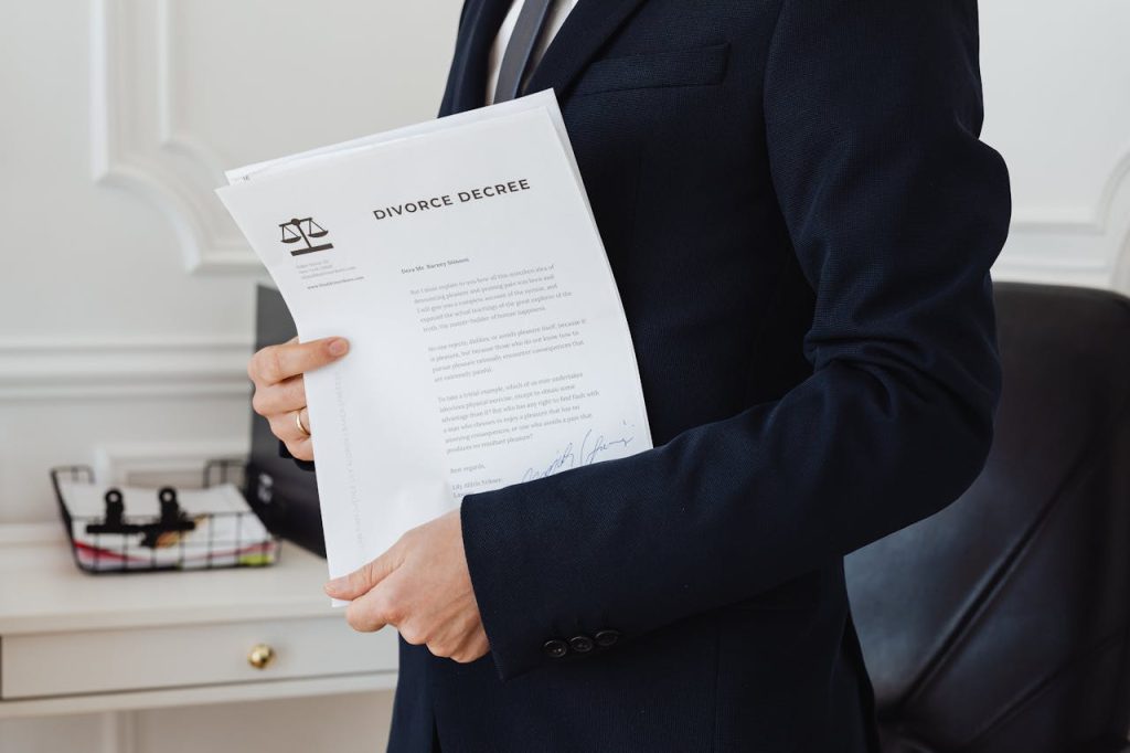 A person holding a divorce decree in an office setting, symbolizing legal proceedings.
